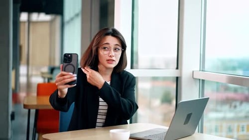 Professional Woman on Mobile Video Call in Office
