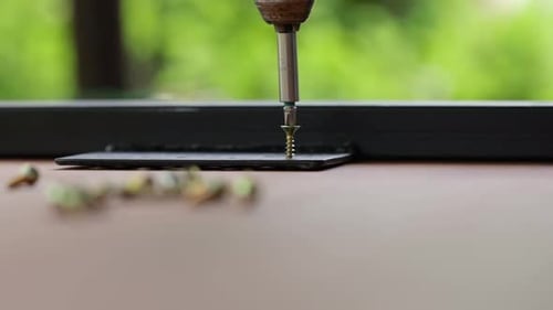 Silver Screw Being Driven In With An Electric Drill