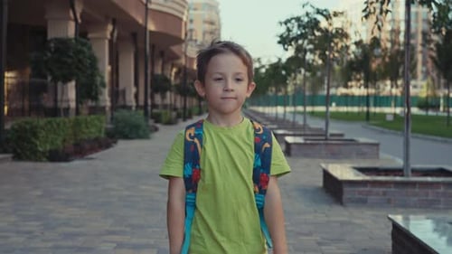 A Happy Child with a Backpack Goes to School
