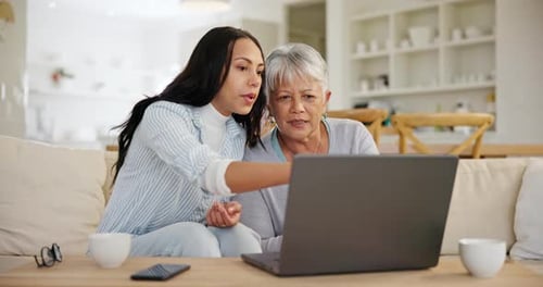 Young Woman Helping Senior Woman with Laptop
