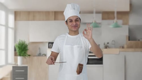 Satisfied Chef Tasting Food in Modern Kitchen