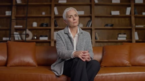 Mature Woman Sitting on a Couch Listening
