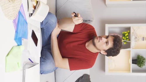 Man Sitting on Couch Talking and Holding Remote
