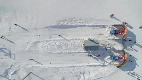 Aerial Top Down View of a Ski Lift Bottom Station Lift Wheels are Spinning Skiers Going Up By Ski