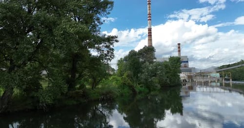 Aerial Drone Shot of Coal Power Plant with Two High Cooling Towers Next to Blue River
