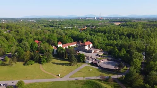 Drone moves left to right and enters in orbit view, house near river with lots of trees around and g