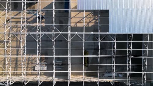 A Construction Site with a Partially Built Warehouse Featuring a Steel Framework and Metal Roof