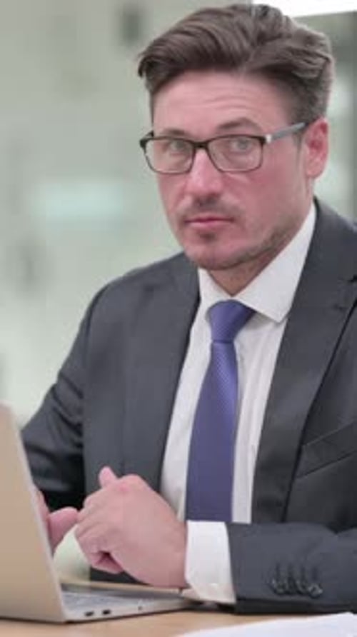 Professional Man Working on Laptop in Bright Office