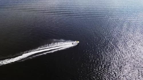 A Man on a Jet Ski Floats Through the Water at High Speed View From Above Aerial Photography of