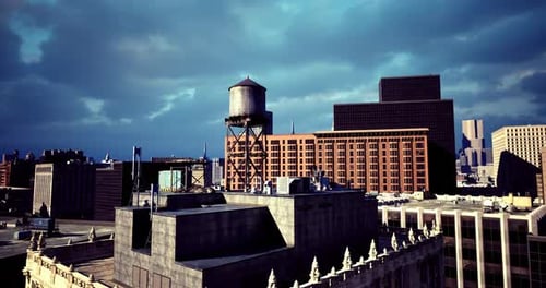 Horizonte urbano con torre de agua y nubes dramáticas sobre los edificios de la ciudad