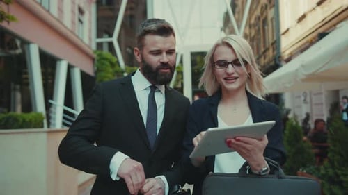 Business People Reviewing Tablet Together Outdoors