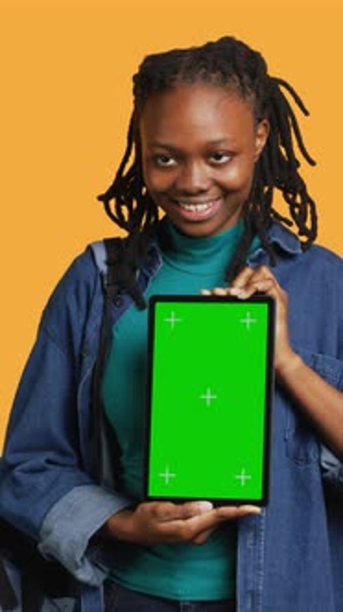 Vertical Video Smiling Woman Presenting Tablet with Green Screen Display Studio Background
