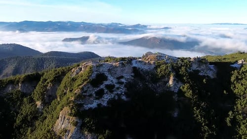 Luftaufnahme der Berglandschaft mit Wald und Tal voller Nebel