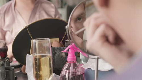 Hombre queer haciendo un contorno de nariz en una habitación entre bastidores