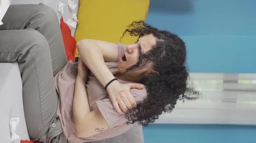 Vidéo verticale d'une jeune femme malade dont les os lui font mal lorsqu'il éternue.