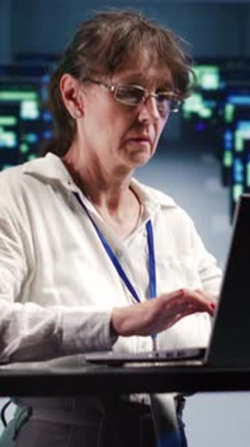 Woman Working on Laptop in Tech Office