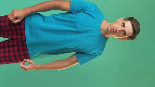 Man Gesturing and Posing Against Green Background