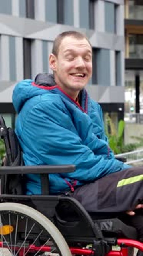 Man in Wheelchair Smiles in Urban Setting