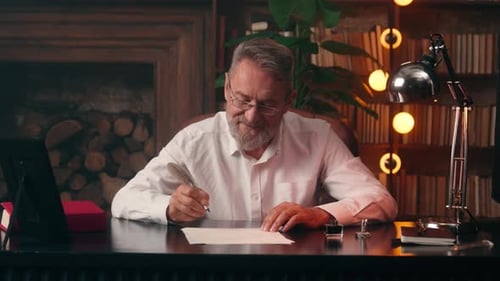 Wrinkled Caucasian Old Man Older Male Senior Writing Paper Office Document Paperwork Looking at