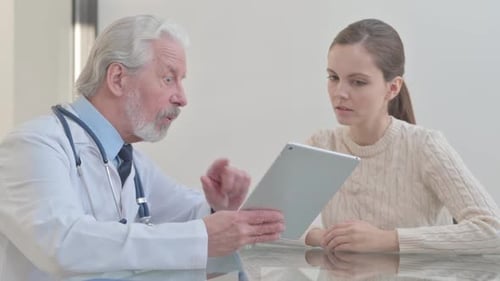 Doctor Explains Medical Information to Woman on Tablet