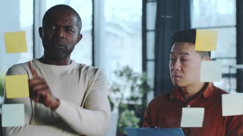 Colleagues Brainstorming Ideas at Workplace with Sticky Notes