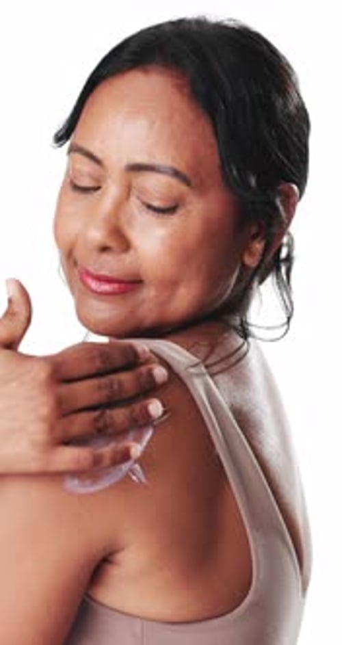 Happy woman, face and skincare with lotion in studio for moisturizer on a white background