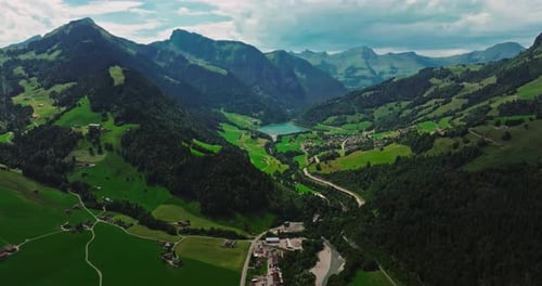 Drohne fliegt über grünes malerisches Tal mit Bergen im Hintergrund Berühmte Hochgebirge
