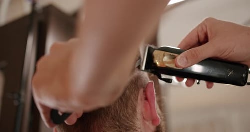 Schöner Mann bekommt neue Frisur mit elektrischem Trimmer Nahaufnahme mit Trimmer
