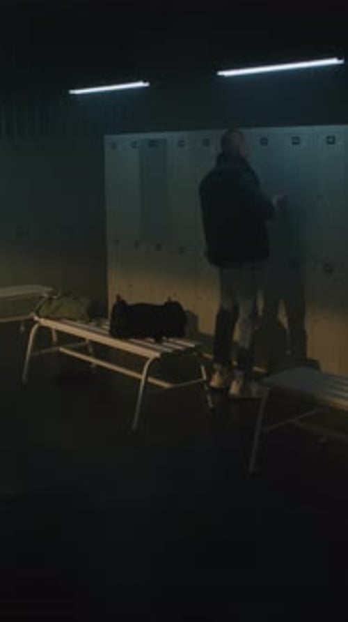 Young Man with Slight Limp Entering Locker Room and Opening Cabinet to Change