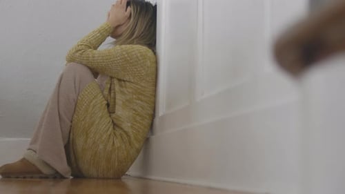 Young Woman Sitting on Floor Feeling Sad
