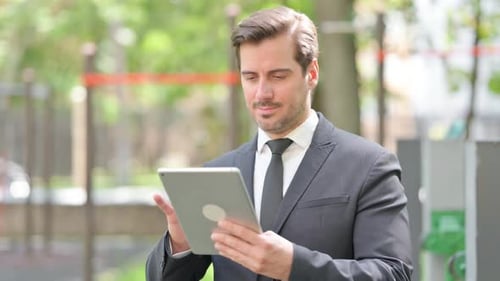 Man Using Tablet Outdoors in Urban Setting