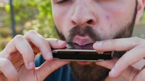 Man Plays Harmonica in Natural Outdoor Setting