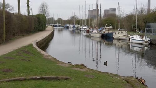 Small sailboats moored on narrow countryside rural canal marina