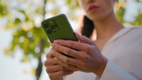 Young Adult Using Mobile Phone in Park Setting