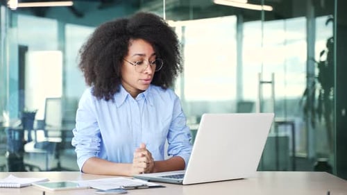 Woman at Laptop Talking in Modern Office