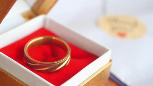 Ein eleganter Goldring, wunderschön präsentiert in einer luxuriösen Geschenkbox mit einer atemberaubenden roten Innenseite