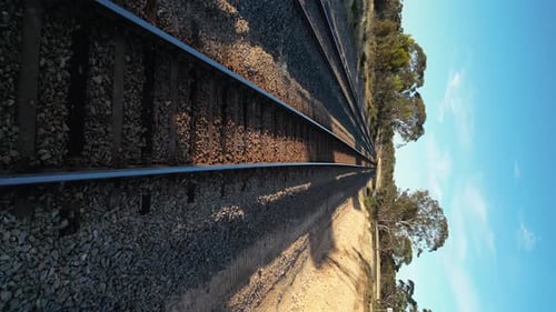 Drohne, die in niedriger Höhe über Bahnschienen in ländlicher Landschaft fliegt. Luftvorwärts und in Zeitlupe. Ve