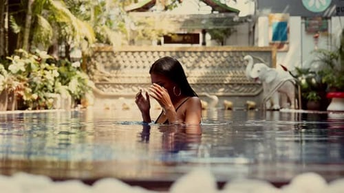Beautiful Woman Relaxing in Tropical Swimming Pool