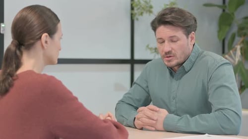 Man and Woman Talking at a Table