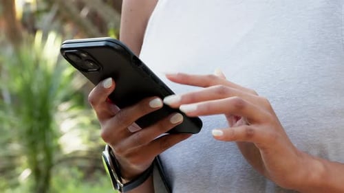 Hands, typing and mobile connection in nature park with wireless connection for social media