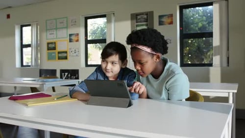 Diverse youth female students responding to prompt, pointing, tapping folio tablet in class solving