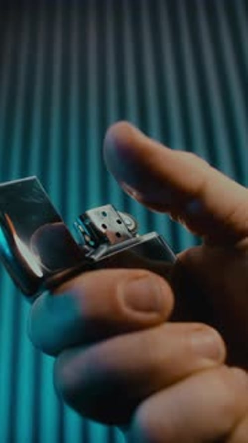 Briquet en métal qui s'ouvre et s'allume au ralenti sur fond bleu