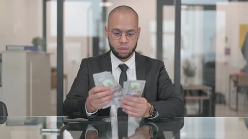 Young Adult Counting Money in Corporate Office