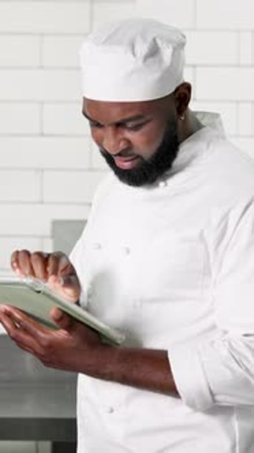 Tablet, black man and chef in kitchen, internet and digital app for recipe