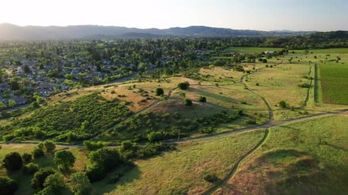 Napa Valley, California. Slow aerial panoramic pan over lush, vibrant green rolling hills along a hi