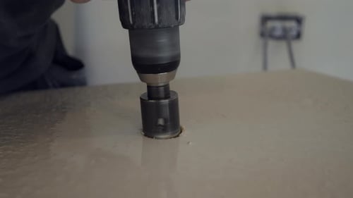 Worker Tiller Drills with a Diamond Core Round Hole in Porcelain Tile
