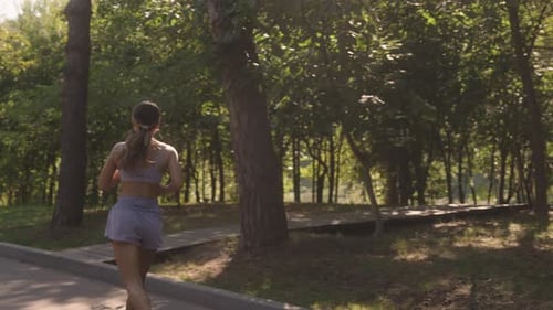 Woman Running Along Path in Green Park