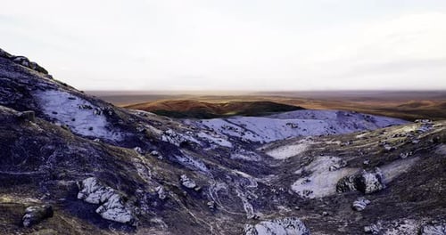 Vast Mountain Landscape with Rocky Slopes Under Soft Sunlight at Dusk