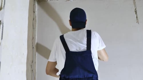 Construction Worker Smoothing Plaster onto Interior Wall