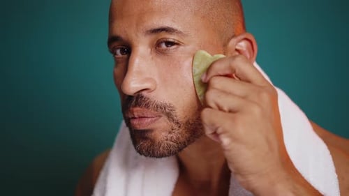 Man Uses Green Gua Sha on Face, Close Up